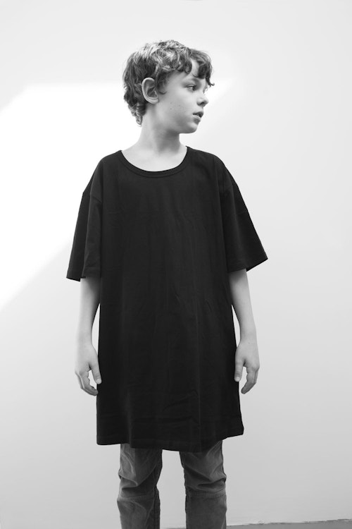 A young boy wearing an oversized t-shirt