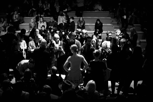 Models surrounded by paparazzis at the closing of a fashion show